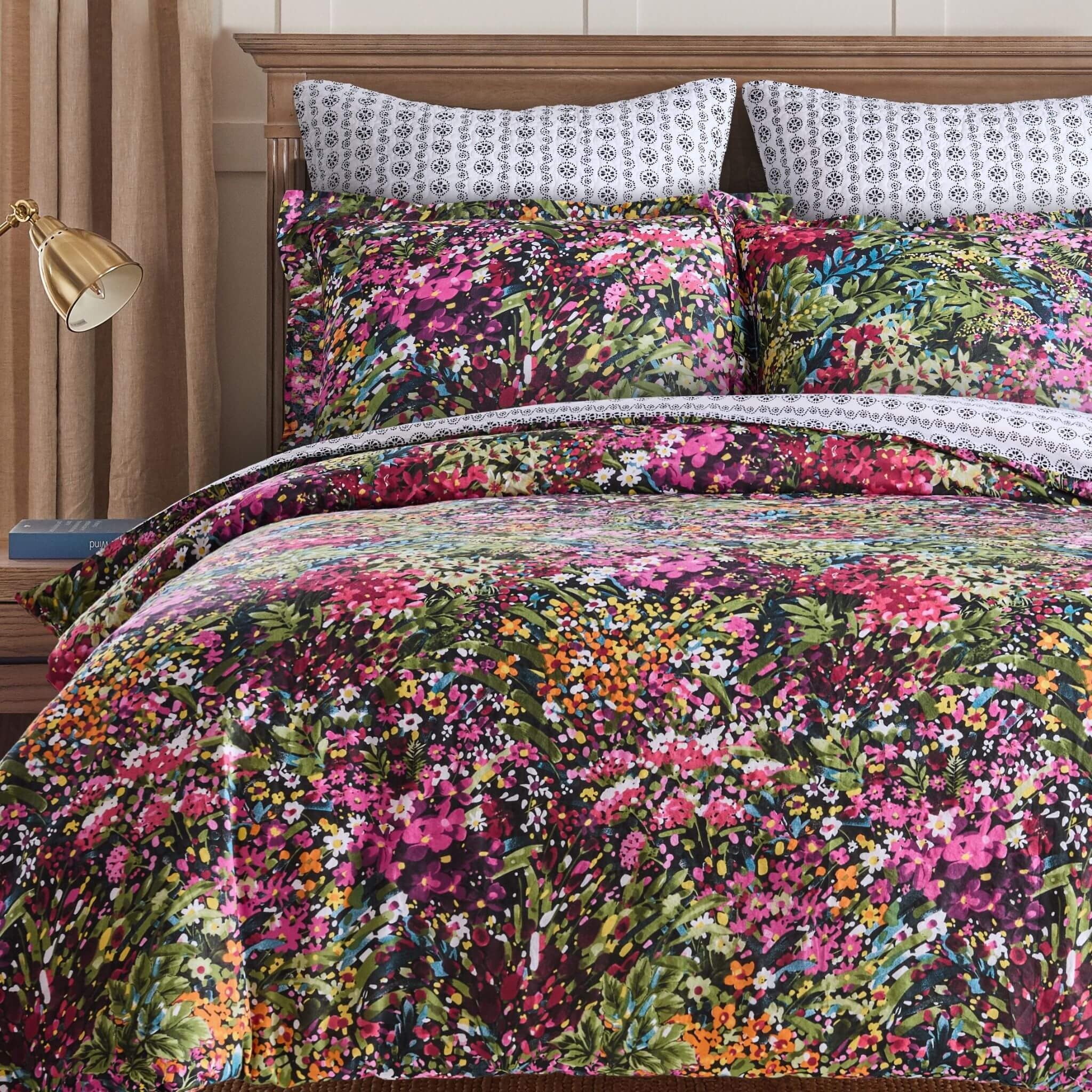 Floral bedding set on a bed with a wooden headboard.