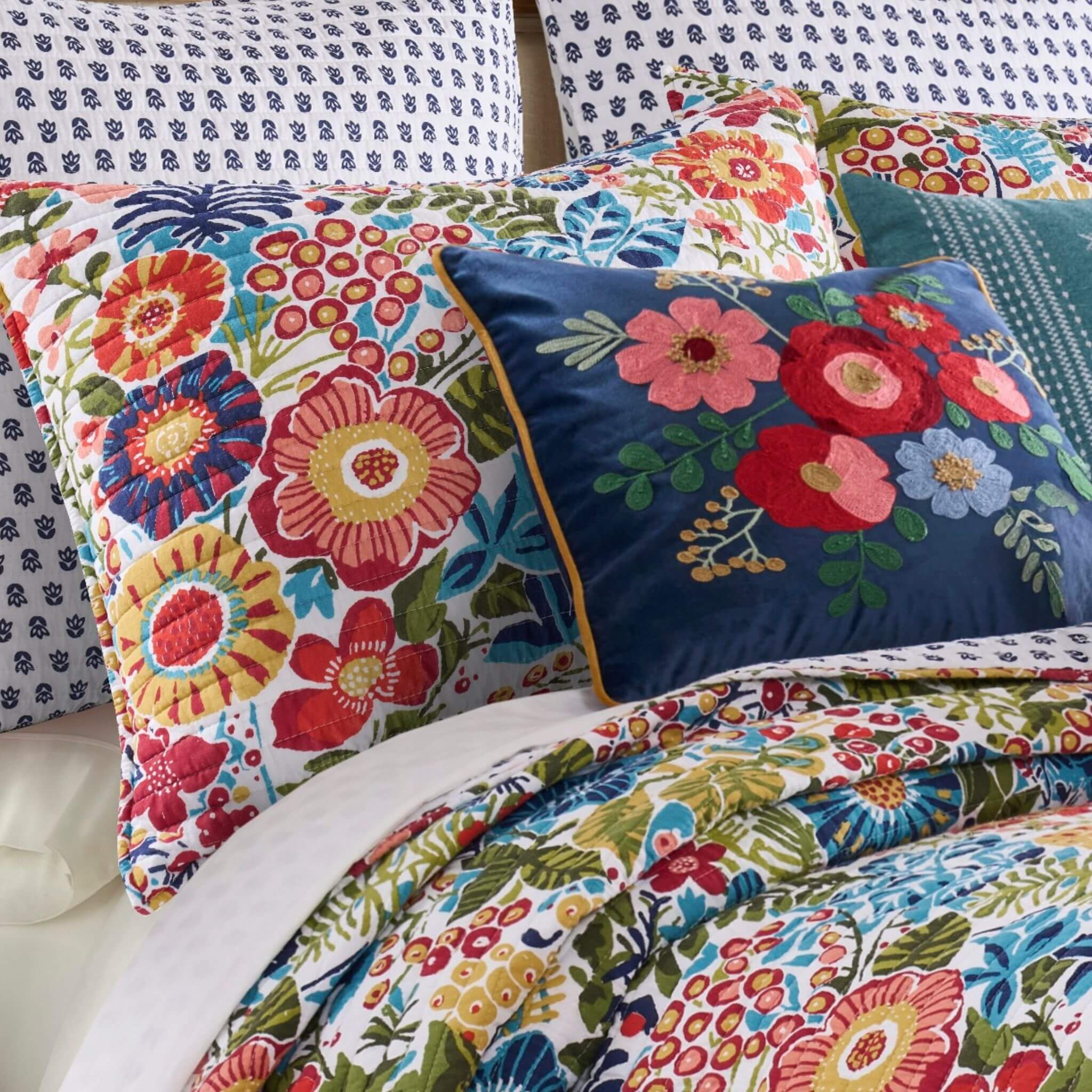 Colorful floral-patterned bedding set on a bed with pillows.