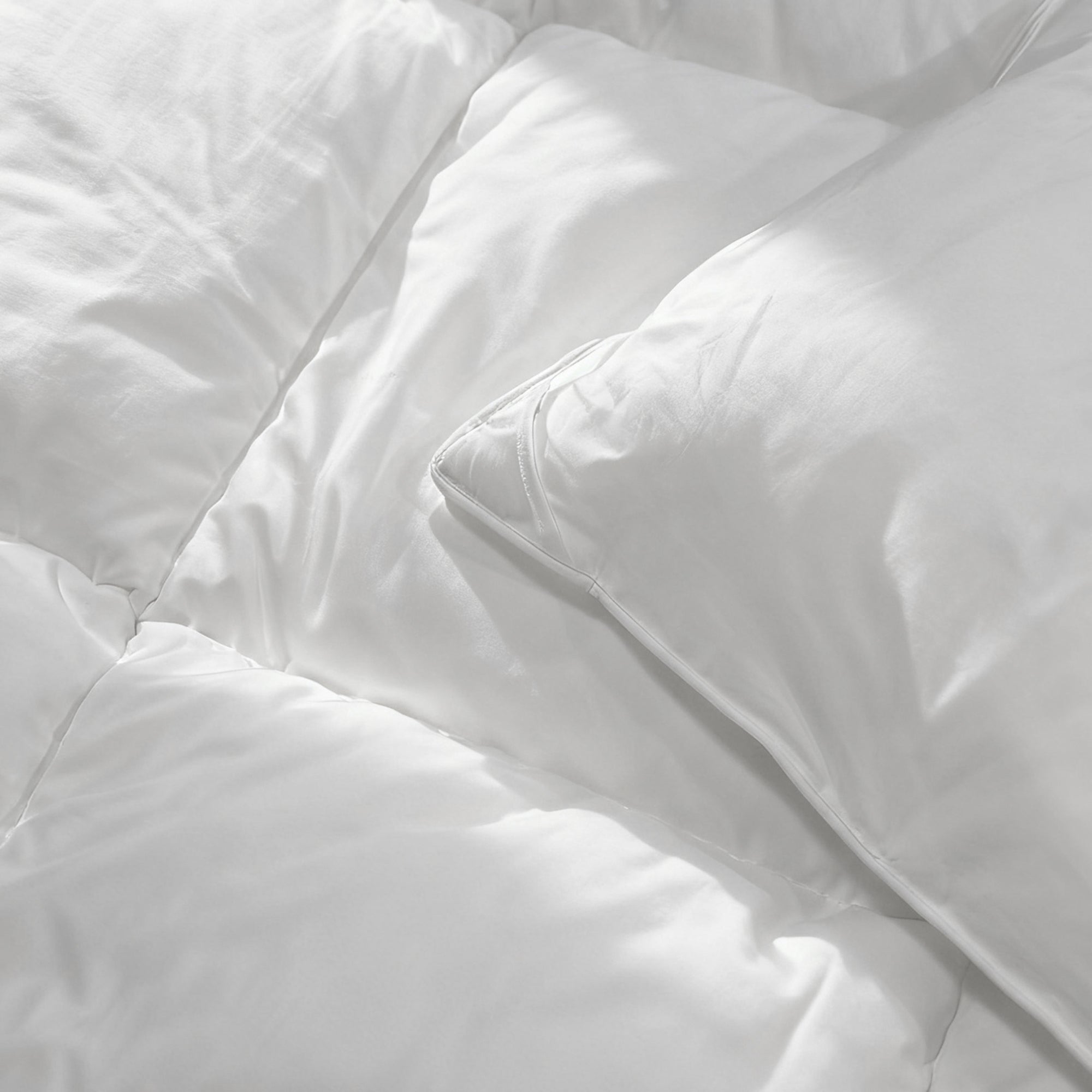 Close-up of the white Levtex Home all-season down-alternative duvet insert and matching pillow, highlighting the smooth cotton shell and plush, box-quilted loft.