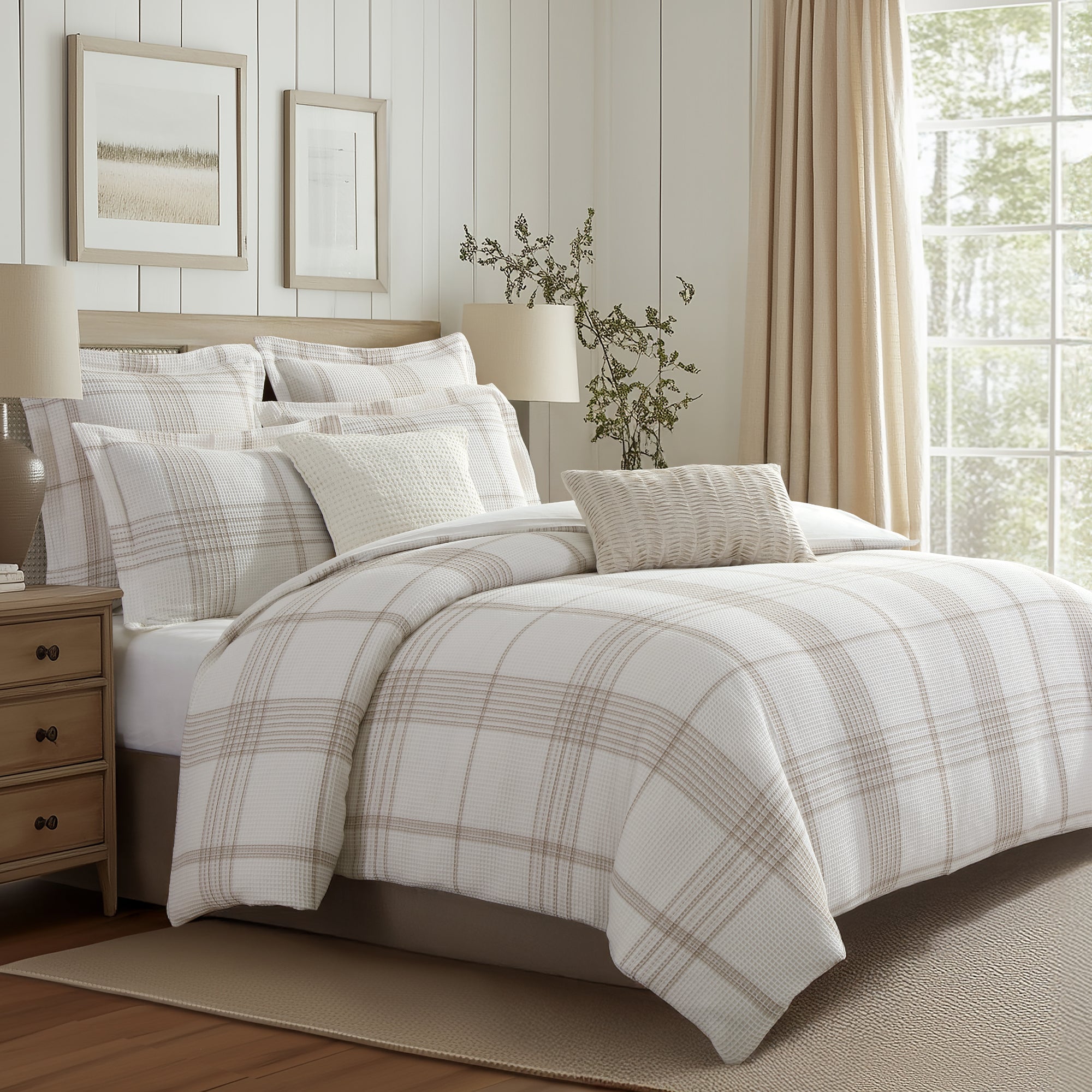 Neatly made bed with plaid bedding in a bedroom setting.