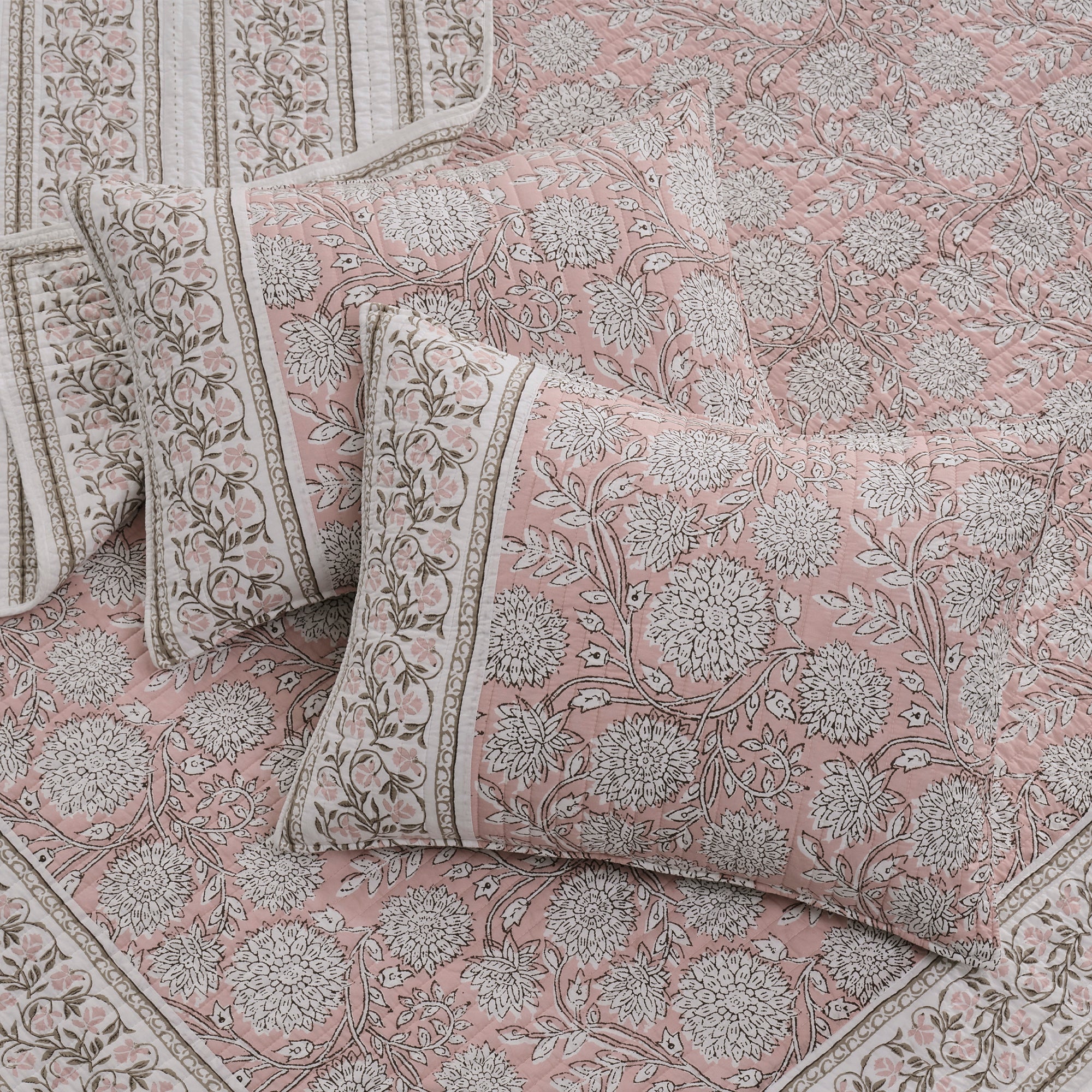 Floral patterned bedding set with pillows on a matching fabric background