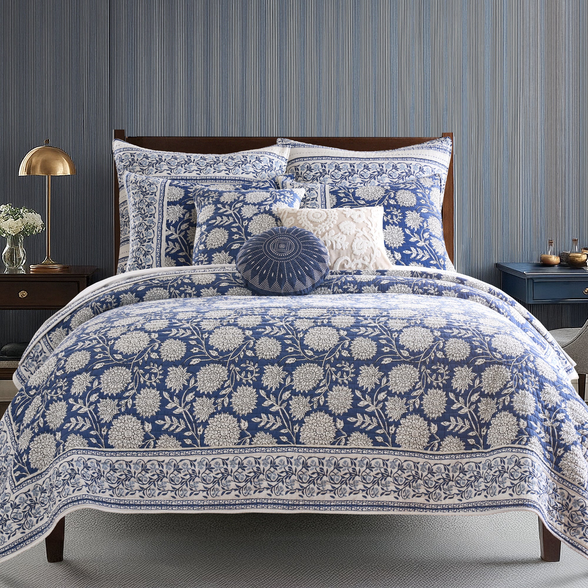 Blue and white floral patterned bedding set on a bed with matching pillows