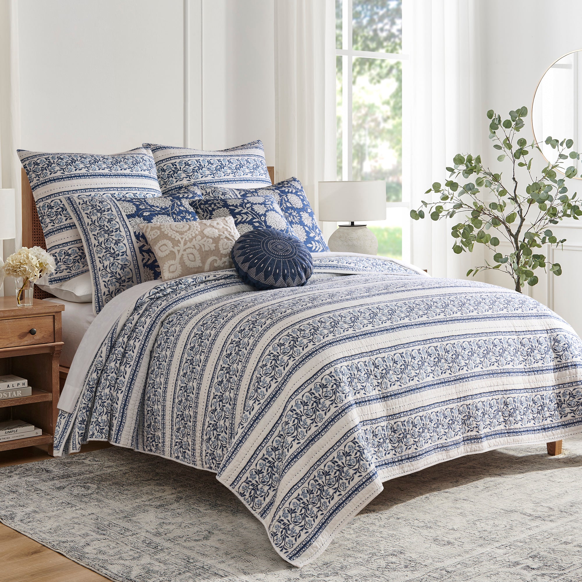 Adare Denim Quilt Set featuring a reversible quilt, 100% cotton fabric, styled with decorative pillows and soft blue tones.