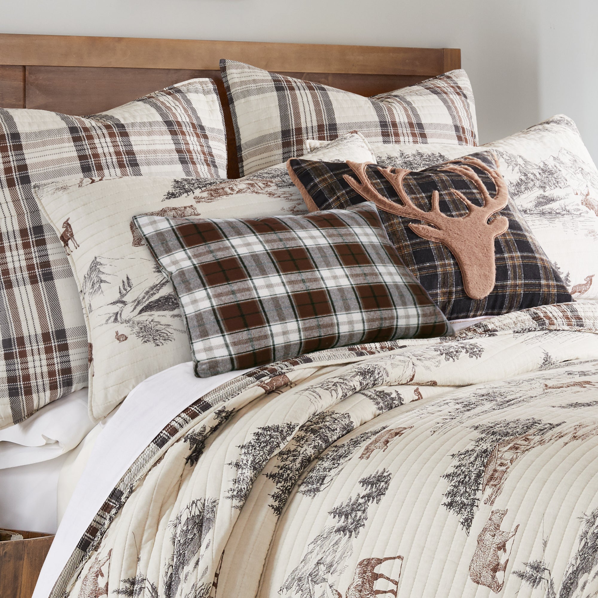 Bed with plaid and patterned pillows and comforter