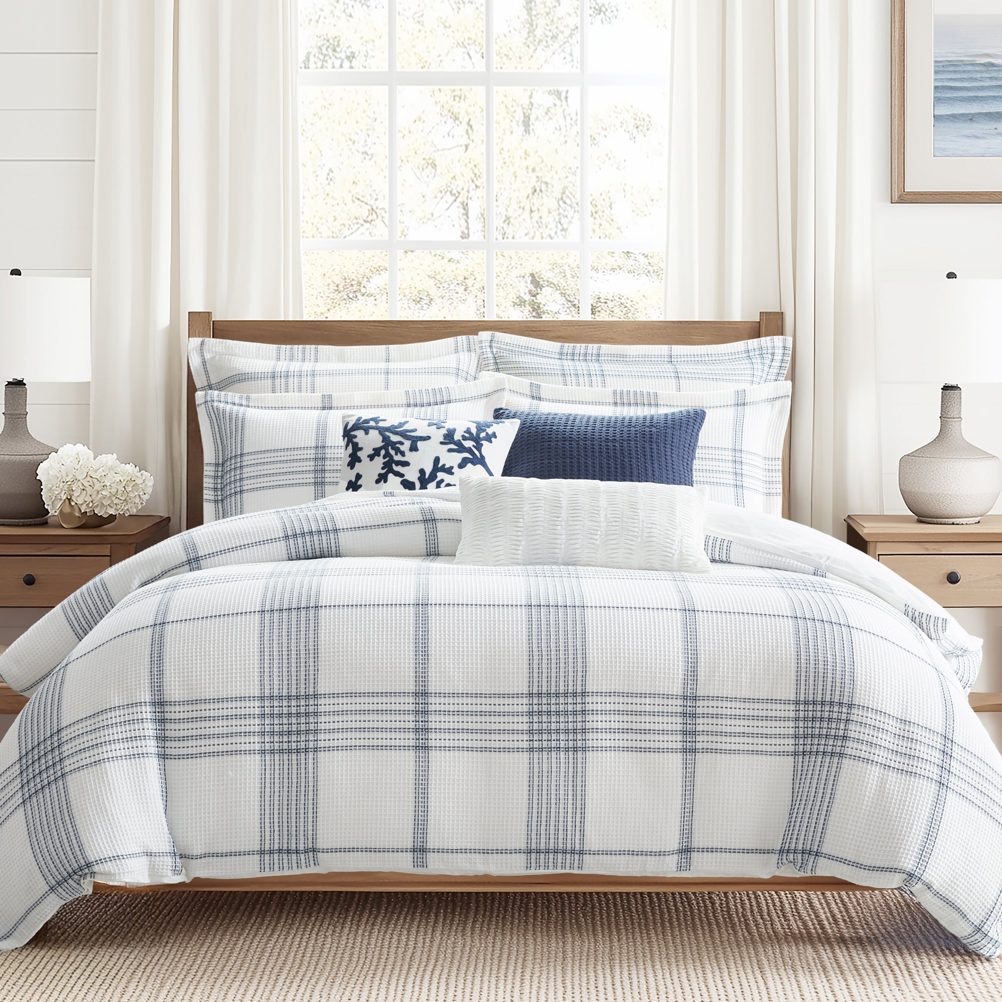 Bedroom with plaid comforter and pillows in a well-lit room
