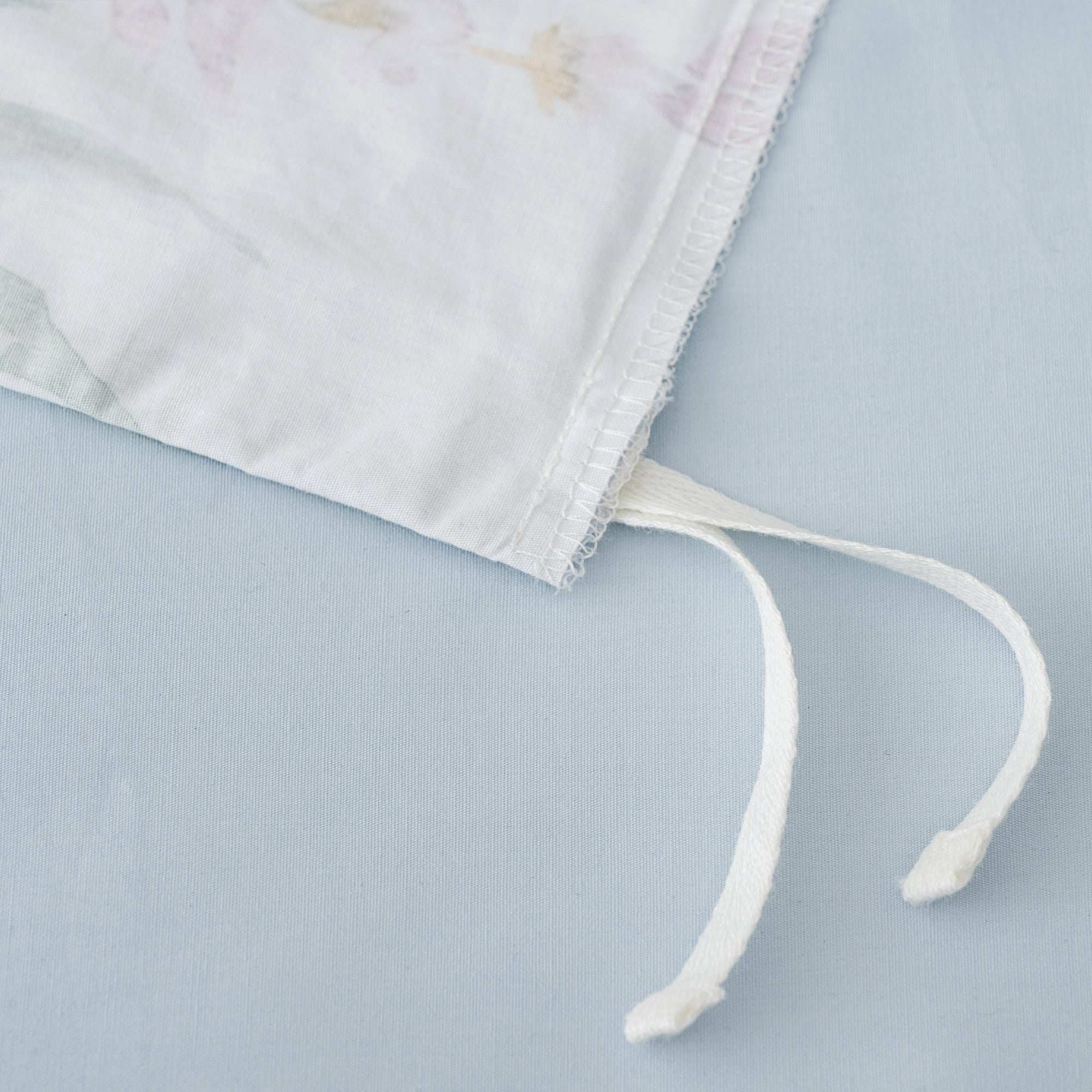 Close-up of the Seraphine Blooms Duvet Cover Set ties showcasing soft cotton fabric and floral design details.