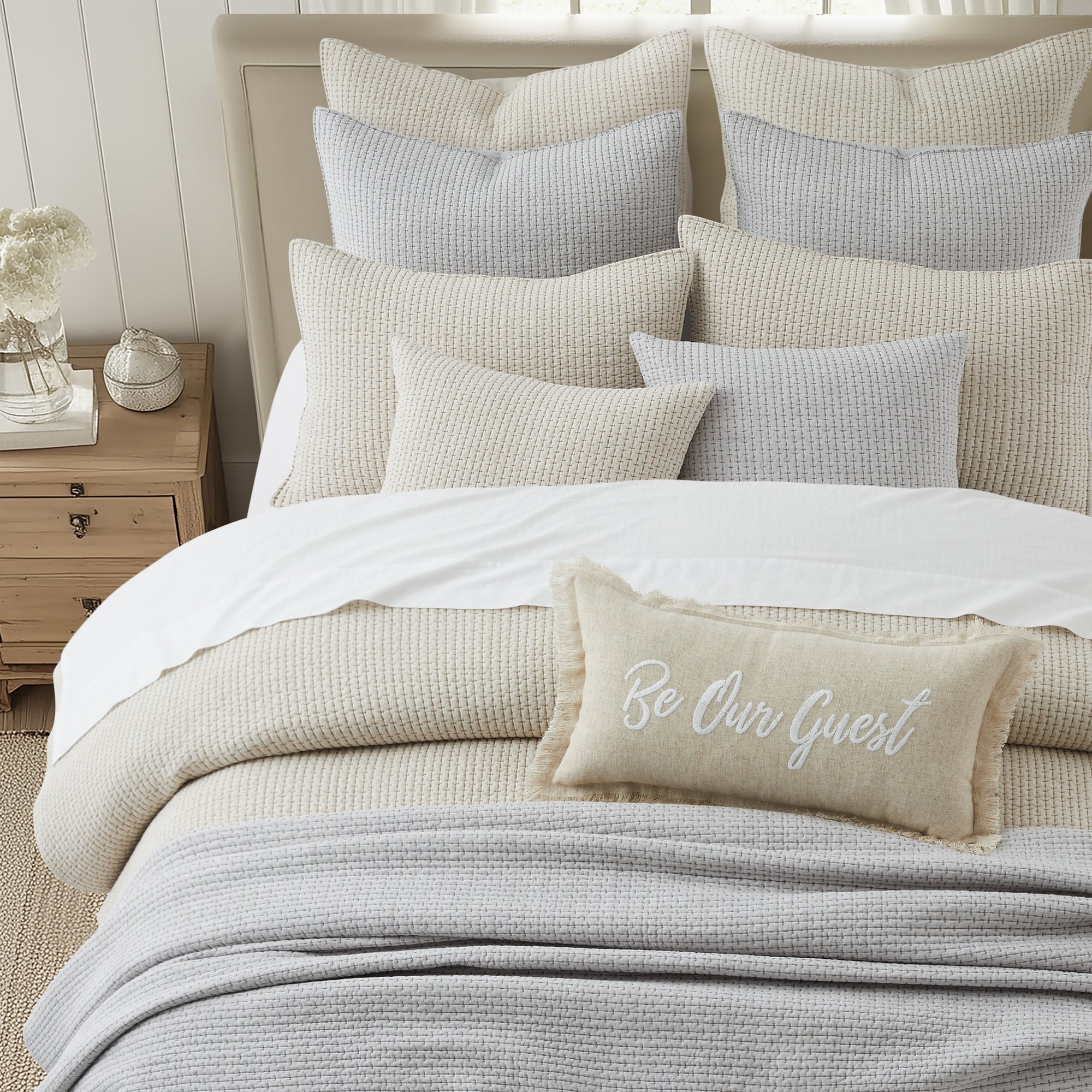 Pick-Stitch Artisan Euro Sham Set of 2 displayed on a cozy bed with a mix of textures and decorative pillows.