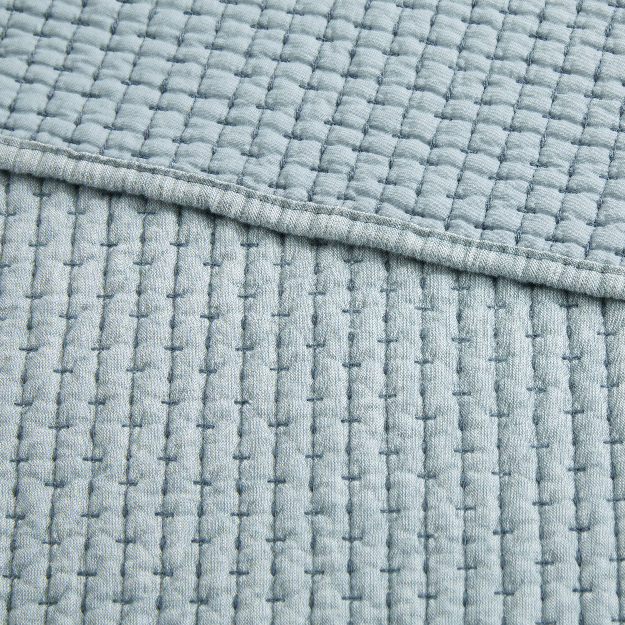 Pick-Stitch Artisan Quilted Throw showcasing a textured gray quilted cotton slub surface with pick-stitch detailing.