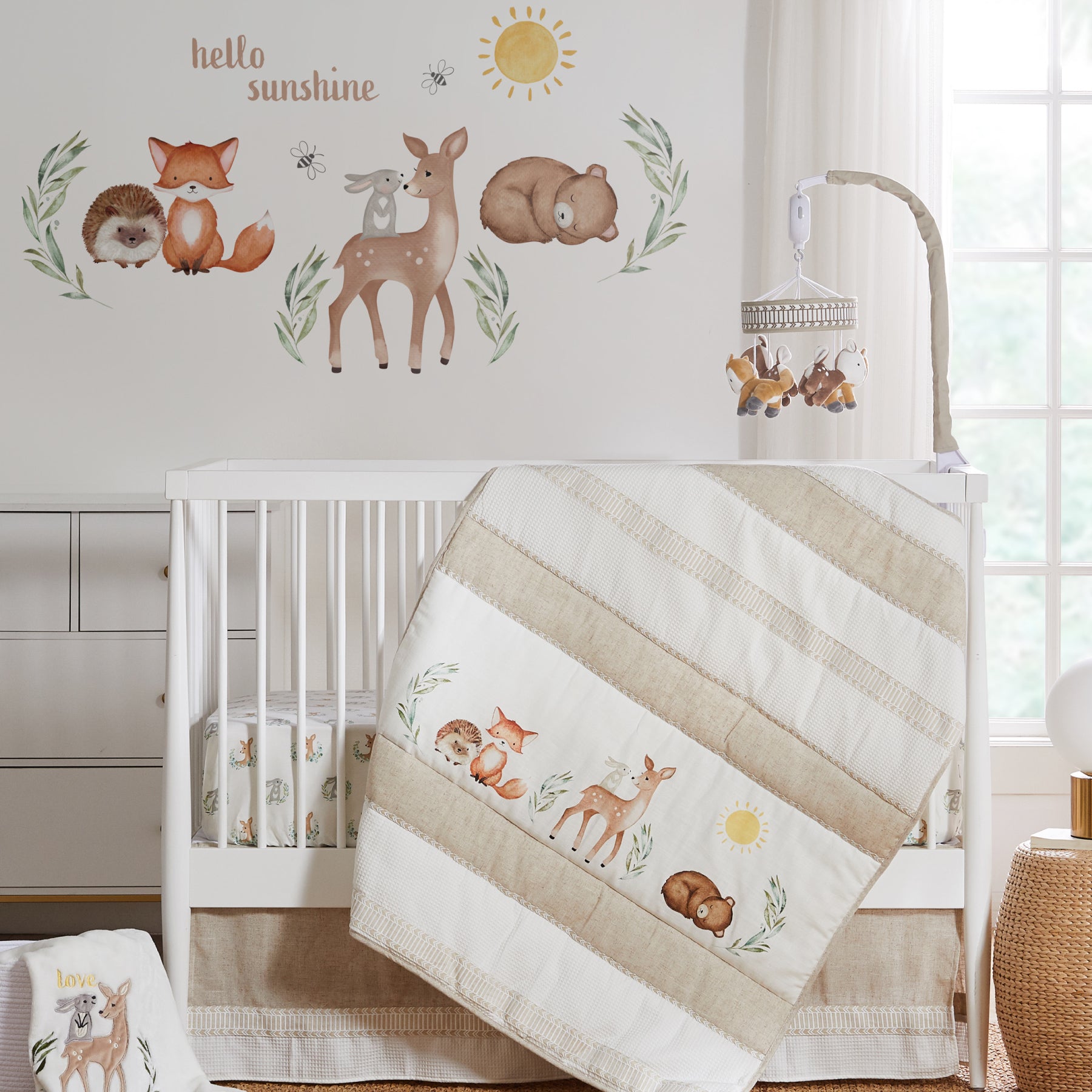 Natural-toned nursery featuring an animal-print bedding set, a white crib, animal wall decals, and matching décor
