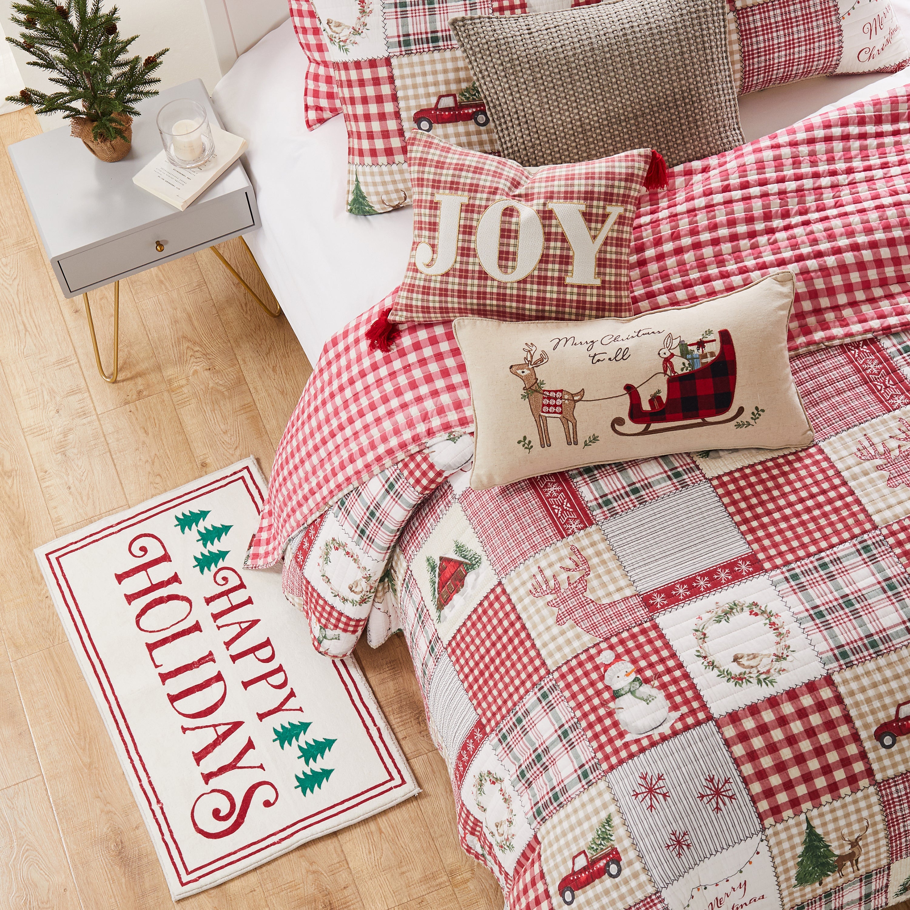 A bed made with Christmas-themed bedding set and matching decorative pillows