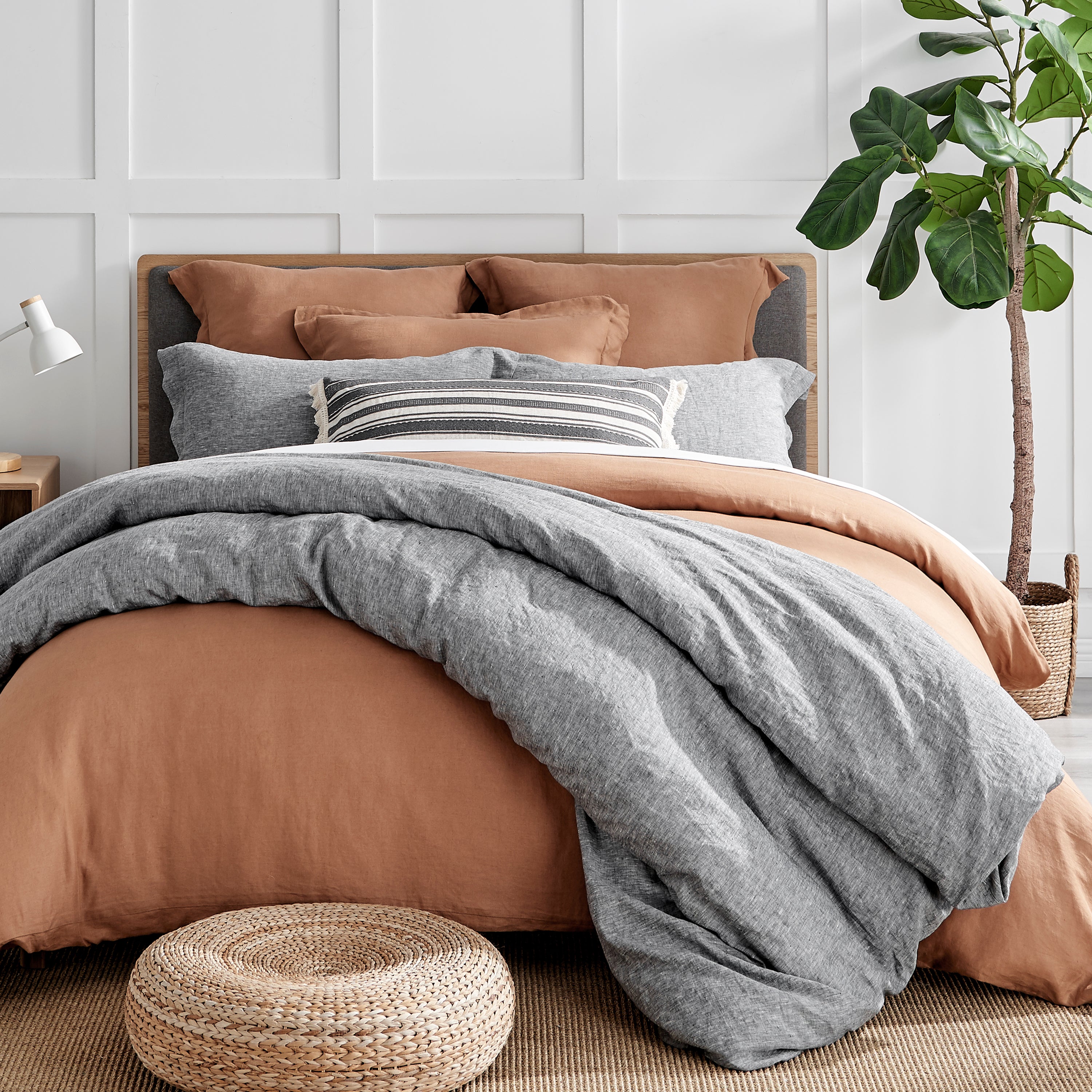 Linen bedding sets in adobe and grey colors  layered on the bed