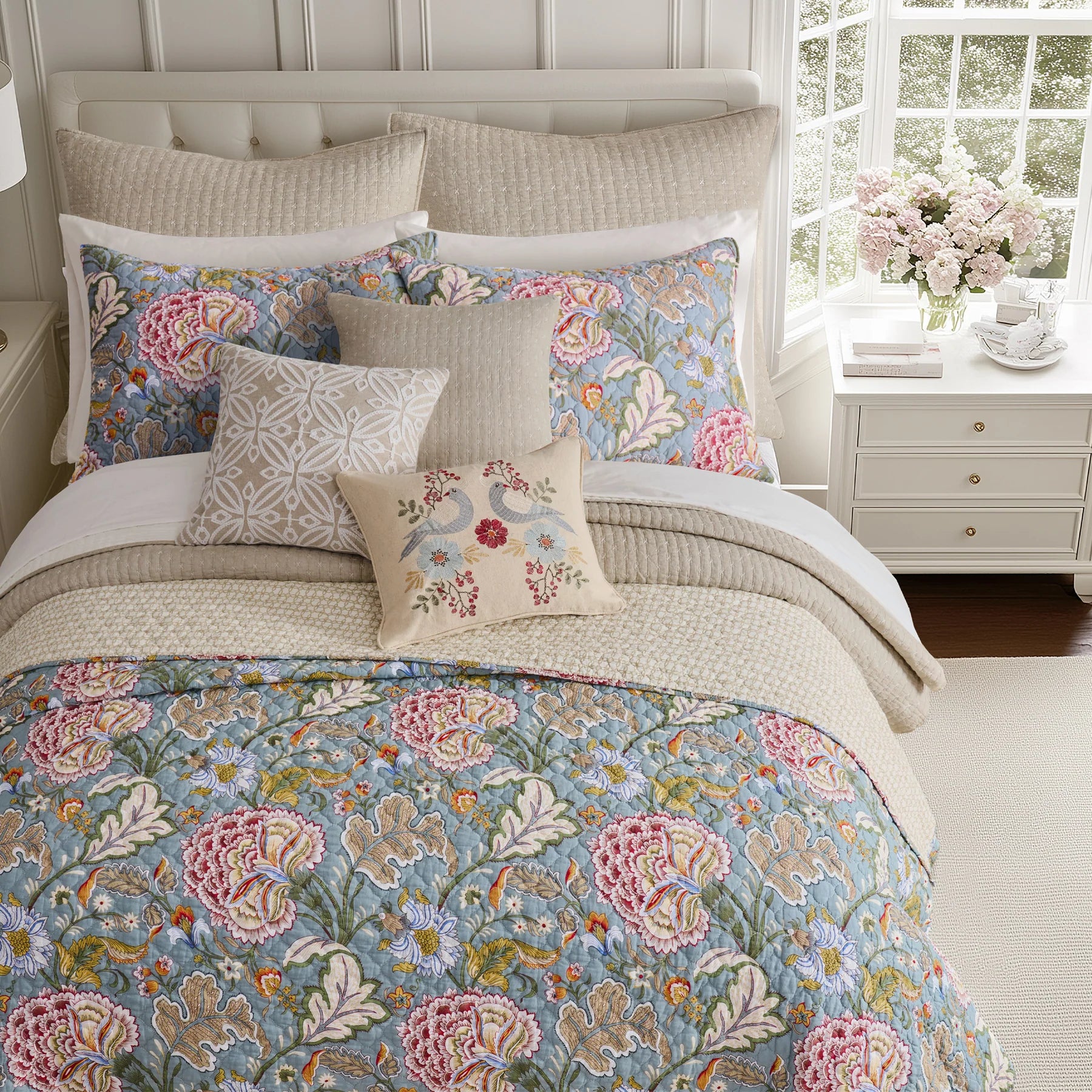 Floral bedding set on a bed with matching pillows in a bedroom setting.