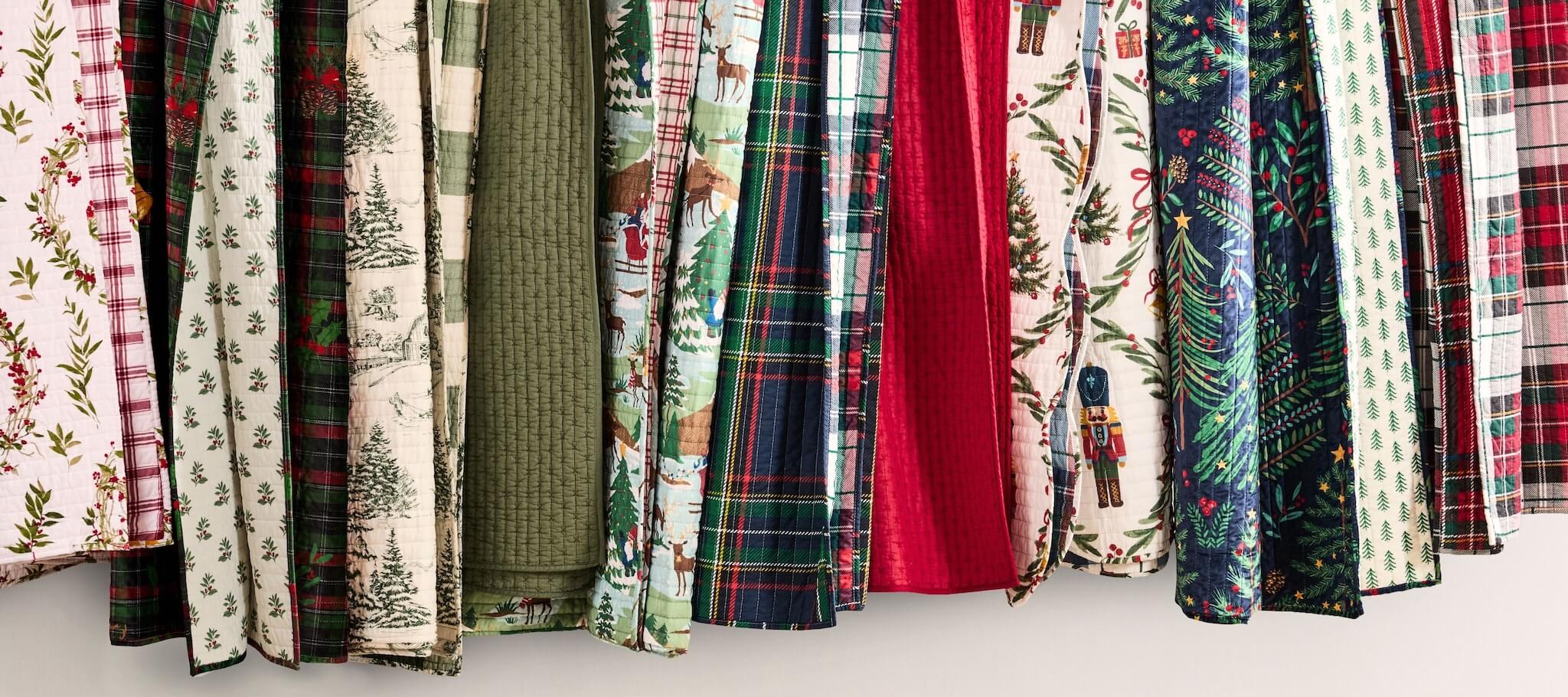 Collection of various patterned Christmas-themed throws on a white background