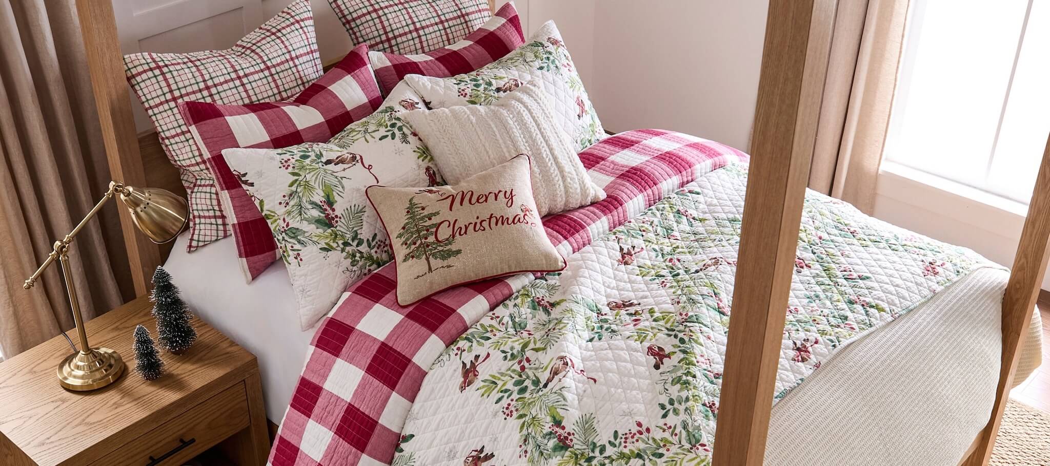 Bed with Christmas-themed bedding and pillows in a cozy bedroom setting.