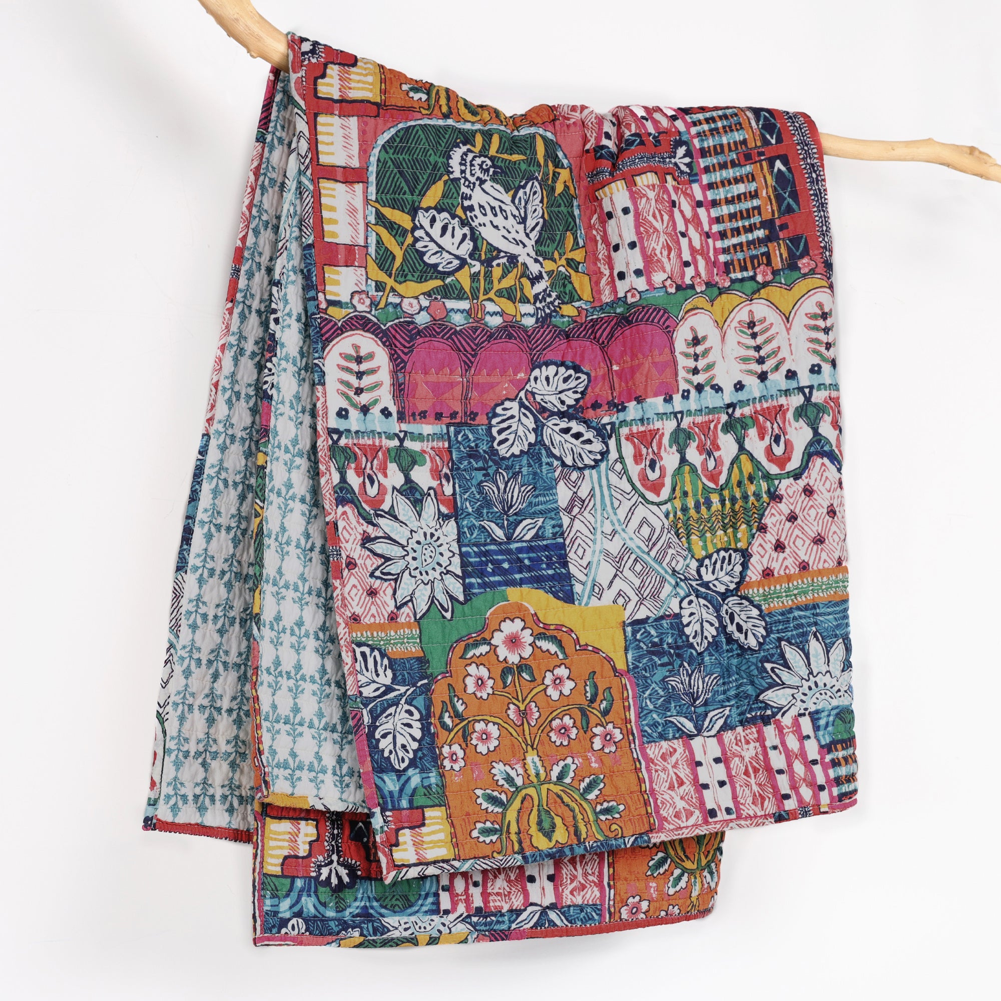 Roshita Quilted Throw featuring vibrant boho patchwork design and botanical reversible pattern.
