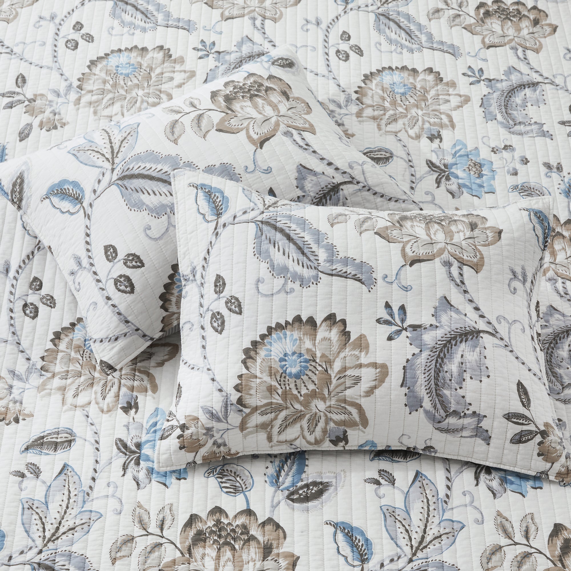 Floral patterned bedding set with pillows on a matching fabric background