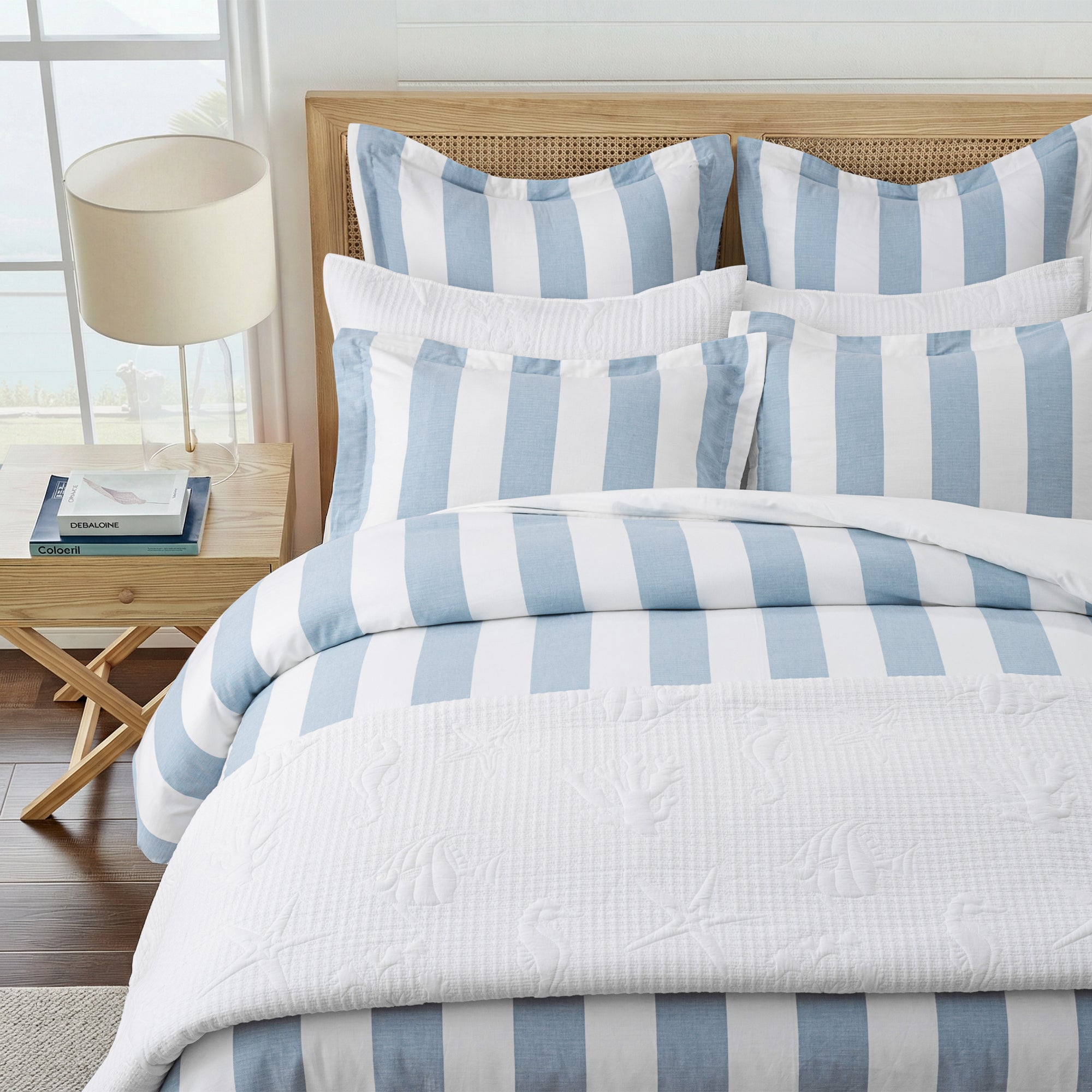 Cabana Stripe Blue Euro Sham Set of 2 Unquilted displayed on a bed with coastal decor and striped patterns.