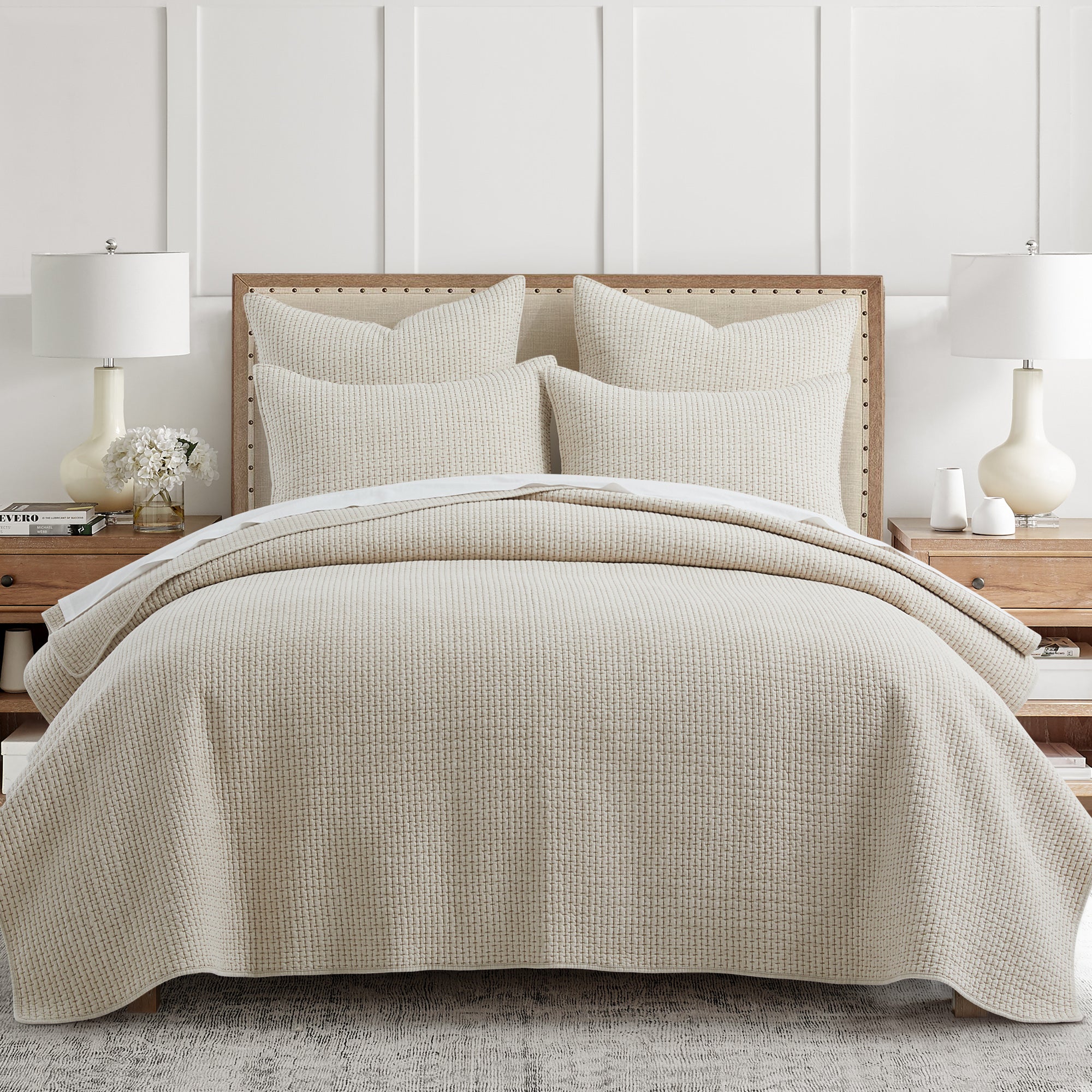 Neatly made bed with beige bedding in a bedroom setting