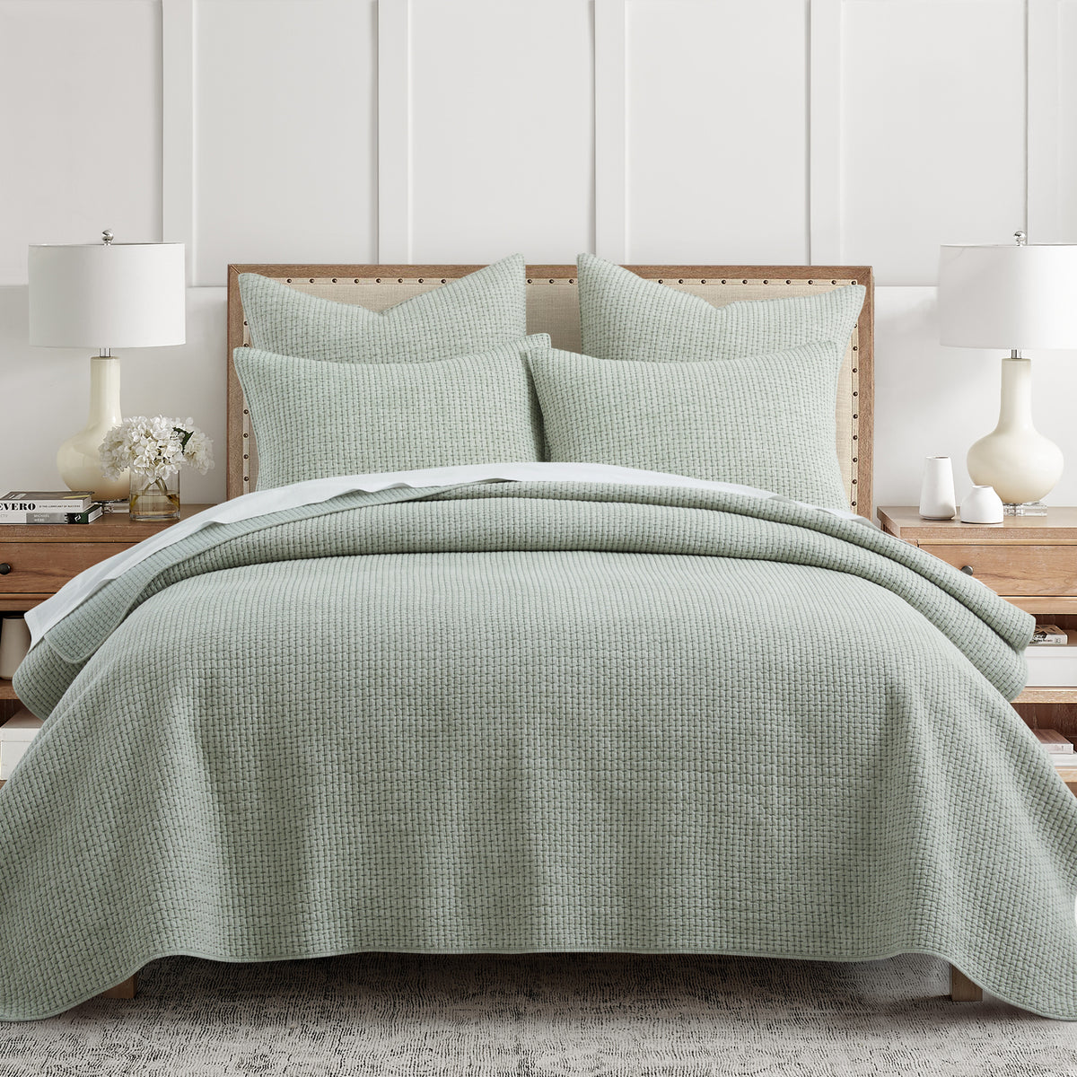 Green checkered quilt and pillow set on a bed in a bedroom setting.