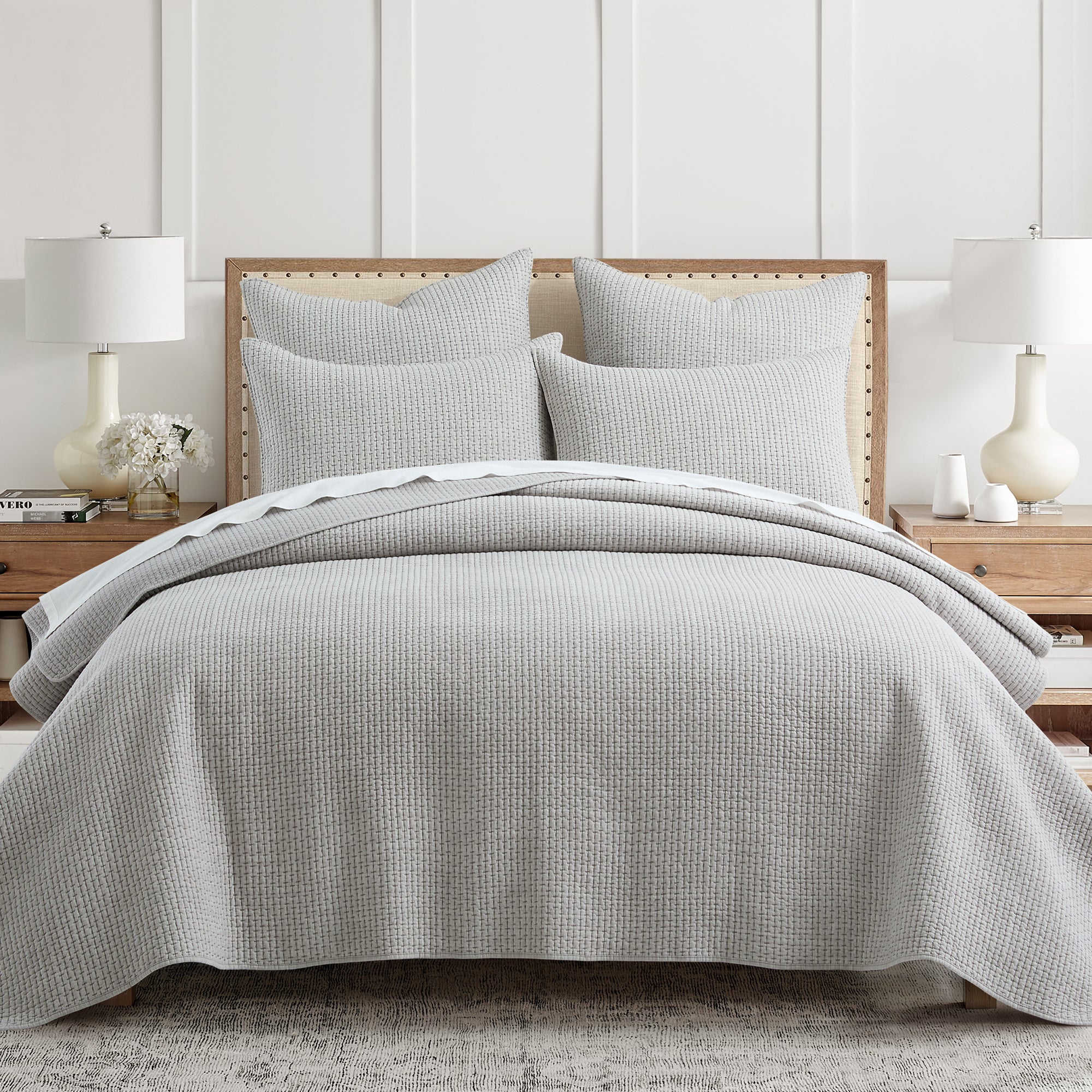 Gray textured bedding set on a bed with matching pillows in a bedroom setting.